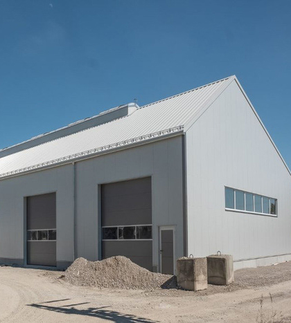 Industriehallen und Gewerbehallen der Firma Aschenbrenner mit grauer Fassade und dunkelgrauen Toren